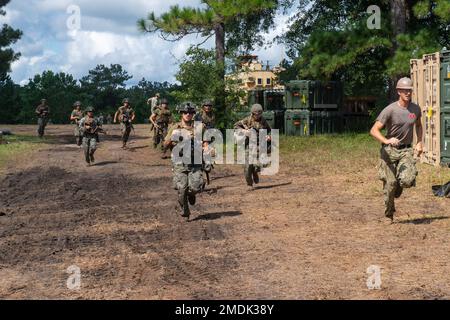 CAMP SHELBY, divers (25 juillet 2022) les Seabés affectés au bataillon de construction mobile de la marine (NMCB) 1 travaillent avec les Marines affectés à l'escadron de soutien de l'escadre de la marine (SMSS) 273 sprint en action lors d'une attaque sur le camp lors de l'opération Turning point, également connue sous le nom d'exercice d'entraînement sur le terrain. Operation Turning point est un exercice 24 heures sur 24 qui se concentre sur la construction de bases avancées tout en maintenant la maîtrise des tactiques et de la capacité de survie. NMCB 1 est domiciliaire à partir de Gulfport, Mils Ils mènent un plan de formation intense à homeport pour accroître leur capacité à exécuter la construction Banque D'Images