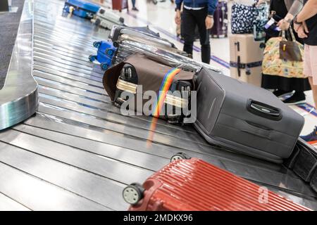 Bagages bagages à l'arrivée de l'aéroport carrousel avec les passagers qui ont l'intention de récupérer le leur Banque D'Images
