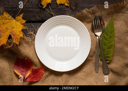 assiette à dîner sur la table en feuilles jaune-rouge d'automne, décoration d'automne de la table, couverts, décorations de table Banque D'Images