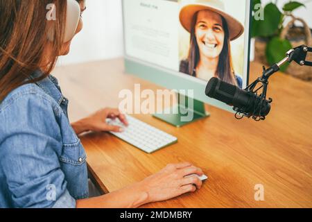Influenceur femme faisant le podcast en utilisant l'ordinateur à la maison - concept de technologie - Focus sur la main tenant la souris Banque D'Images