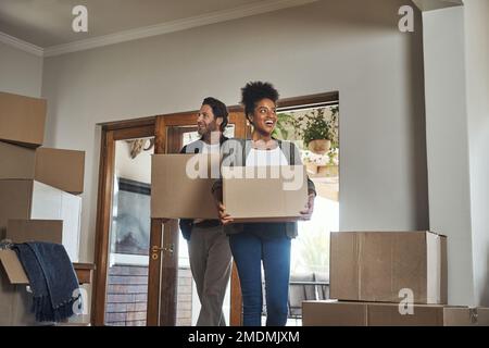Nous avons trouvé la maison parfaite. un jeune couple souriant tout en portant des boîtes dans leur nouvelle maison. Banque D'Images