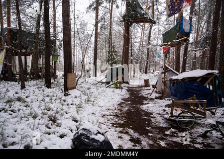 23 janvier 2023, Saxe, Ottendorf-Okrilla: Les activistes du climat marchent dans une forêt occupée par eux. L'occupation, qui a commencé à l'été 2021, est connue par le slogan 'Heibo bleibt'. La date limite pour le défrichement de la parcelle de forêt occupée au nord-est de Dresde, qui doit être défriché pour l'expansion d'une fosse de gravier, est en train de s'éteindre. Photo: Matthias Rietschel/dpa Banque D'Images