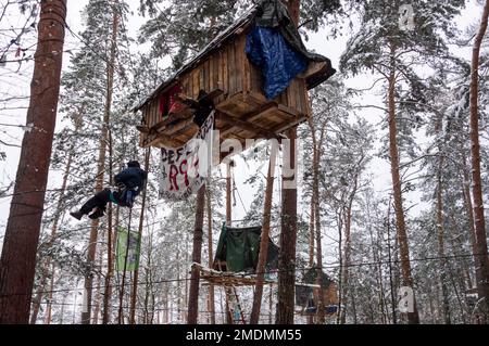 23 janvier 2023, Saxe, Ottendorf-Okrilla: Les activistes du climat marchent dans une forêt occupée par eux. L'occupation, qui a commencé à l'été 2021, est connue par le slogan 'Heibo bleibt'. La date limite pour le défrichement de la parcelle de forêt occupée au nord-est de Dresde, qui doit être défriché pour l'expansion d'une fosse de gravier, est en train de s'éteindre. Photo: Matthias Rietschel/dpa Banque D'Images