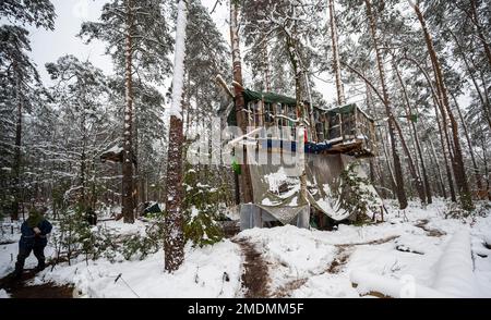 23 janvier 2023, Saxe, Ottendorf-Okrilla: Les activistes du climat marchent dans une forêt occupée par eux. L'occupation, qui a commencé à l'été 2021, est connue par le slogan 'Heibo bleibt'. La date limite pour le défrichement de la parcelle de forêt occupée au nord-est de Dresde, qui doit être défriché pour l'expansion d'une fosse de gravier, est en train de s'éteindre. Photo: Matthias Rietschel/dpa Banque D'Images