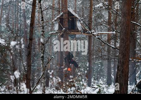 23 janvier 2023, Saxe, Ottendorf-Okrilla: Les activistes du climat marchent dans une forêt occupée par eux. L'occupation, qui a commencé à l'été 2021, est connue par le slogan 'Heibo bleibt'. La date limite pour le défrichement de la parcelle de forêt occupée au nord-est de Dresde, qui doit être défriché pour l'expansion d'une fosse de gravier, est en train de s'éteindre. Photo: Matthias Rietschel/dpa Banque D'Images