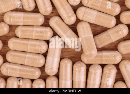 Capsules de poudre de plantes sur fond en bois. Vue de dessus. Pose à plat. Gros plan Banque D'Images