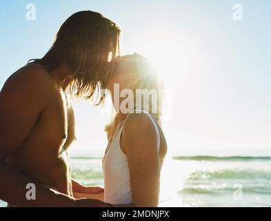 La lyve ne se sentait jamais plus près. un jeune couple affectueux s'embrassant à la plage. Banque D'Images