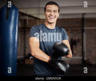 Fitness, portrait et homme avec des gants de boxe dans la salle de gym pour l'entraînement, l'exercice ou l'entraînement. Heureux, sourire et athlète ou boxeur de sexe masculin faisant de la kickboxing cardio Banque D'Images