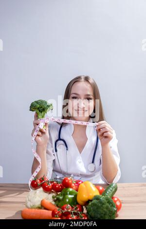 Portrait d'une nutritionniste féminine dans son bureau. Un nutritionniste tient un mètre ruban dans ses mains. Manger sainement. Banque D'Images