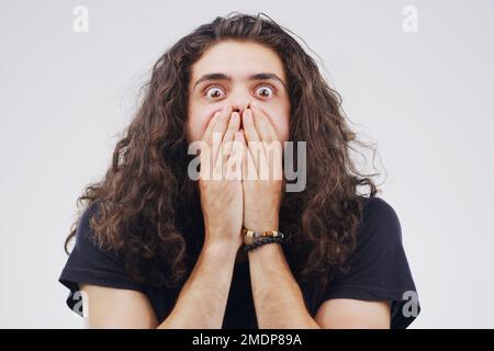 C'est ce que j'ai vu de plus sympa toute la journée. Photo studio d'un jeune homme qui a l'air choqué sur un fond gris. Banque D'Images