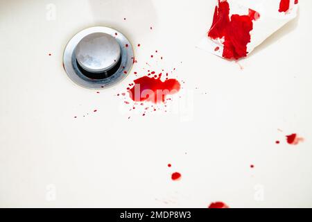 Gouttes de sang rouge dans le lavabo blanc de la salle de bains. Le sang réel comme traces et l'ADN preuve d'un crime. Concept d'une scène de violence, de meurtre ou de suicide. Banque D'Images
