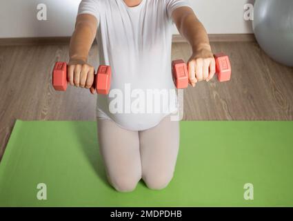 Une fille enceinte entre pour le sport dans le 3rd trimestre de la grossesse. Fitness et Pilates. La santé des femmes. Banque D'Images