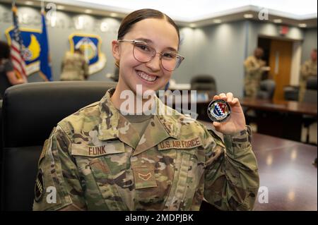 Classe Airman 1st Kelly Funk, technicien en gestion financière de l'escadron 66th du contrôleur, détient une pièce présentée par le colonel Taona Enriquez, commandant de l'installation, à la suite d'une réunion à la base de la Force aérienne Hanscom, Massachusetts, 26 juillet. Funk a été inventé par le commandant pour exécuter des tâches en dehors de son domaine de carrière. Banque D'Images