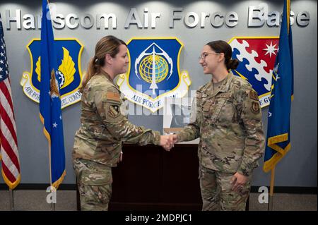 Le colonel Taona Enriquez, à gauche, commandant de l'installation, présente à Airman la classe 1st Kelly Funk, technicienne en gestion financière du 66th e Escadron de contrôleur, sa pièce lors d'une réunion à la base aérienne Hanscom, Mass., 26 juillet. Funk a été inventé par le commandant pour exécuter des tâches en dehors de son domaine de carrière. Banque D'Images