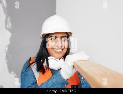 Une femme attirante d'Asie du Sud porte des planches en bois porte des vêtements de construction Banque D'Images