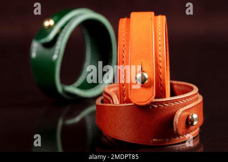 Bracelets en cuir avec détails métalliques sur fond sombre. Banque D'Images