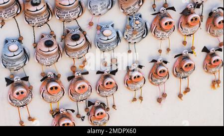 Dudutki, Bélarus - 12 juin 2022 : de nombreux souvenirs sous forme de chats et de cochons sont accrochés à bord. Arrière-plan Banque D'Images