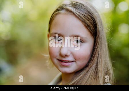 Portrait d'une fille debout à l'extérieur en forêt. Banque D'Images