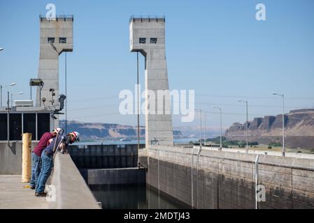 Les membres de la équipage d’exploitation et d’entretien du barrage John Day, situé sur la rivière Columbia près de Rufus, Oregon, regardent vers le bas l’écluse de navigation du barrage 26 juillet tandis que les ingénieurs inspectent la porte en amont de l’écluse, qui a fait mal à 25 juillet en raison d’une roue de guidage cassée. Alors que le corps travaille pour fixer la porte de levage verticale de 215 000 livres, il continue de passer des navires à travers la serrure à l'aide d'une cloison flottante, un mur qui peut être déplacé et déplacé à l'intérieur avec un remorqueur et essentiellement utilisé comme porte temporaire. Actuellement, les écluses de navires, qui prennent généralement environ 45 minutes, prennent deux fois plus de temps. Le Banque D'Images