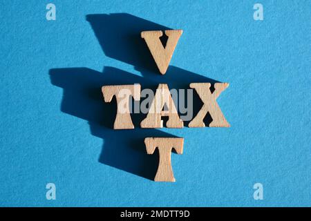 Taxes, TVA, mot et acronyme en lettres de l'alphabet en bois en forme de mots croisés isolées sur fond bleu avec espace de copie Banque D'Images