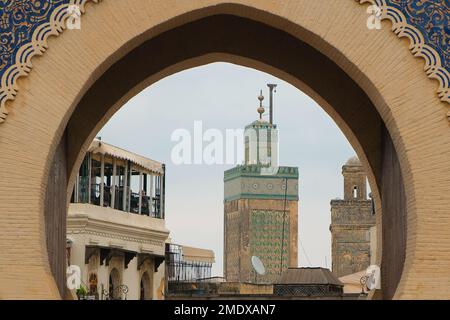 Fès, Maroc - minarets de Marinid Bou Inania Madrasa par la porte de la ville de Bab Bou Jeloud. Entrée française monumentale dans l'ancienne médina de Fès el Bali. Banque D'Images