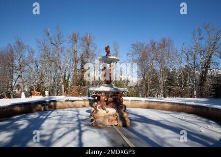 Ségovie, Espagne - 4 janvier 2022 : Fontaine des trois Grâces dans les jardins du Palais Royal de la Granja de San Ildefonso couverte de neige sur une da ensoleillée Banque D'Images