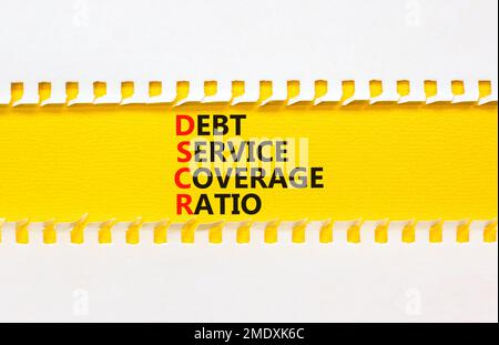 Symbole du ratio de couverture du service de la dette DSCR. Mots de concept DSCR ratio de couverture du service de la dette sur papier jaune sur fond blanc magnifique. DSCR d'entreprise d Banque D'Images