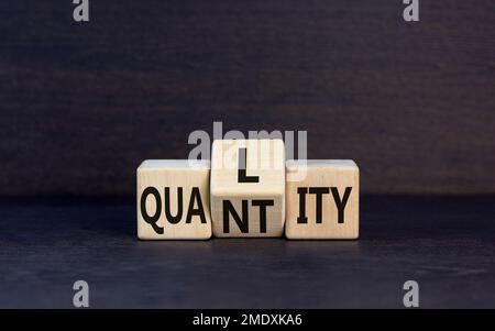 Symbole de qualité et de quantité. Concept Word qualité quantité sur cubes en bois. Beau tableau noir fond noir. Affaires et qualité et quantité Banque D'Images