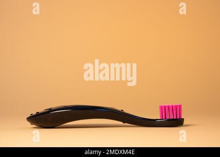 Brosse à dents en plastique rose fluo pour bébé sur fond naturel. Concept dentaire et de soins de santé Banque D'Images