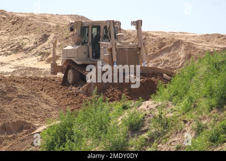 Un soldat d’ingénieur de la Compagnie des ingénieurs 390th de Chattanooga, dans la réserve de l’Armée de terre, exploite un 26 juillet 2022 de terrassement mobile de bulldozer, dans le cadre d’un projet de troupes en cours à fort McCoy, Le projet se trouve dans une zone de terrain près de l'ancienne porte 20 et de la base d'entraînement tactique améliorée Liberty et la clôture de la zone de cantonnement, a déclaré Larry Morrow, coordonnateur des projets de troupes à la Direction des travaux publics de fort McCoy (DPW). Le plan du site est du transformer en site de support des opérations de base pour les entrepreneurs de service d'installation, tels que l'entretien des installations, les routes et les terrains, les déchets solides, la crème anglaise Banque D'Images