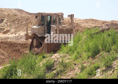 Un soldat d’ingénieur de la Compagnie des ingénieurs 390th de Chattanooga, dans la réserve de l’Armée de terre, exploite un 26 juillet 2022 de terrassement mobile de bulldozer, dans le cadre d’un projet de troupes en cours à fort McCoy, Le projet se trouve dans une zone de terrain près de l'ancienne porte 20 et de la base d'entraînement tactique améliorée Liberty et la clôture de la zone de cantonnement, a déclaré Larry Morrow, coordonnateur des projets de troupes à la Direction des travaux publics de fort McCoy (DPW). Le plan du site est du transformer en site de support des opérations de base pour les entrepreneurs de service d'installation, tels que l'entretien des installations, les routes et les terrains, les déchets solides, la crème anglaise Banque D'Images