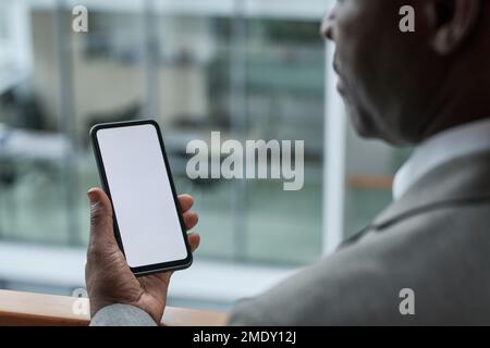 Gros plan de la main de l'homme d'affaires mature tenant un smartphone avec écran vide avec espace de copie pour votre texte d'annonce ou de publicité Banque D'Images