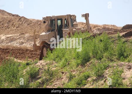 Un soldat d’ingénieur de la Compagnie des ingénieurs 390th de Chattanooga, dans la réserve de l’Armée de terre, exploite un 26 juillet 2022 de terrassement mobile de bulldozer, dans le cadre d’un projet de troupes en cours à fort McCoy, Le projet se trouve dans une zone de terrain près de l'ancienne porte 20 et de la base d'entraînement tactique améliorée Liberty et la clôture de la zone de cantonnement, a déclaré Larry Morrow, coordonnateur des projets de troupes à la Direction des travaux publics de fort McCoy (DPW). Le plan du site est du transformer en site de support des opérations de base pour les entrepreneurs de service d'installation, tels que l'entretien des installations, les routes et les terrains, les déchets solides, la crème anglaise Banque D'Images