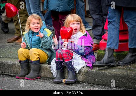 Jeunes filles assis sur le trottoir d'observation Parade, Banque D'Images