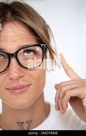 Photo de tête blonde élégante cheveux courts femme avec des lunettes et un casque regardant vers le haut. Banque D'Images