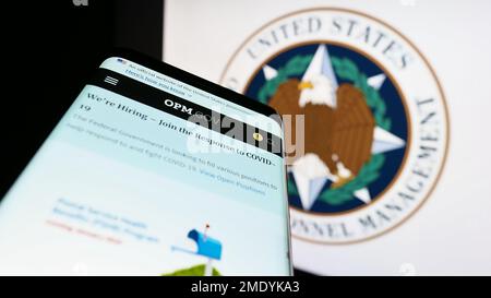 Smartphone avec le site Web de l'Office of personnel Management (OPM) des États-Unis sur l'écran devant le sceau. Faites la mise au point dans le coin supérieur gauche de l'écran du téléphone. Banque D'Images