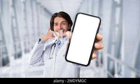 Concept de télémédecine. Sourire Docteur Homme tenant un smartphone vierge et gestuelle appelez-moi Banque D'Images