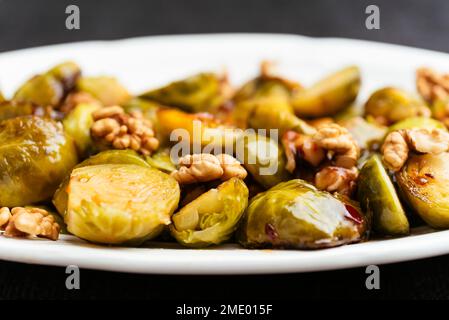 Choux de Bruxelles doux et épicés avec des noix en accompagnement. Banque D'Images