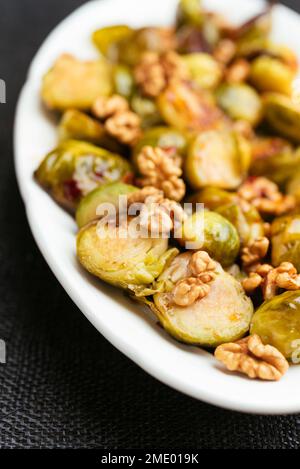 Choux de Bruxelles doux et épicés avec des noix en accompagnement. Banque D'Images