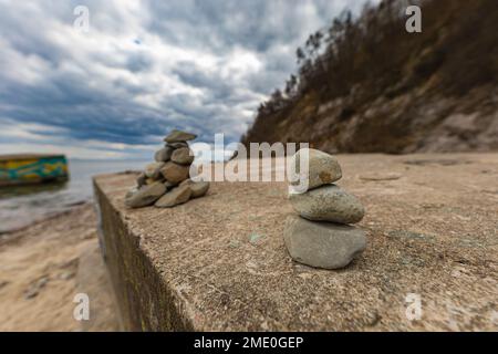 Petite pile de petites pierres sur roche géante au bord de la plage à côté de la mer Baltique Banque D'Images