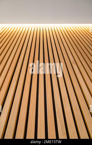 Le revêtement de planches lisses en bois verticales est éclairé par la lumière artificielle. Panneaux en bois clair avec une belle texture. Fait partie du Banque D'Images