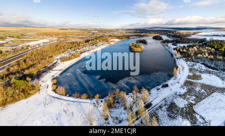 Vue panoramique aérienne d'un lac gelé entouré de neige Banque D'Images