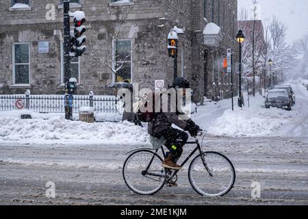 Montréal, CA, le 17 décembre 2022 : Homme à vélo sur l'avenue Mont-Royal pendant une tempête de neige Banque D'Images