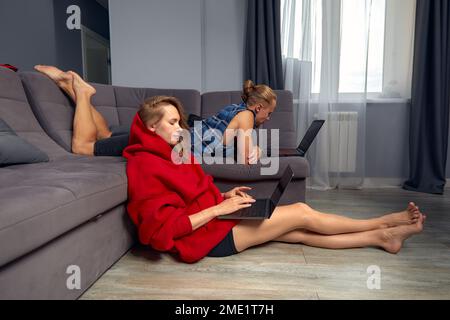 Jeune famille couple homme femme travail à la maison sur des ordinateurs, travail à distance, affaires familiales, travail à la maison Banque D'Images