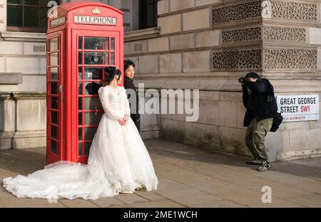 Une mariée et un marié posent pour un photographe devant une emblématique boîte téléphonique rouge dans le centre de Londres, janvier 2023 photo: Jacquelin Magnay Banque D'Images