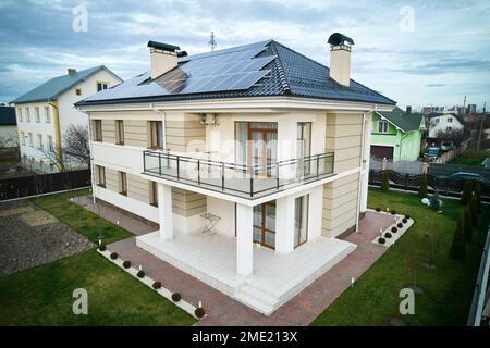 Résidence avec système de panneaux solaires pour la production d'électricité par l'effet photovoltaïque. Nouvelle maison de deux étages avec modules solaires sur le toit. Concept de sources d'énergie écologiques renouvelables. Banque D'Images