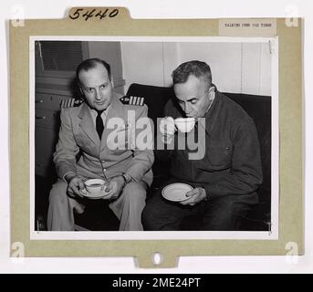 Bering Sea Patrol - parler des temps anciens. Le père Bernard R. Hubbard, S. J. (à droite), géologue de l'Université de Santa Clara, en Californie, et le capitaine Earl K. Rhodes, USCG, commandant du brise-glace DE la Garde côtière NORTHWIND, sont de nouveau des 's' pendant la patrouille de la mer de Béring en 1950. Le célèbre « Glacier Priest » a navigué avec le capitaine Rhodes il y a de nombreuses années, alors que ce dernier était lieutenant à bord de l'ancien garde-côte NORTHLAND. Une tasse de café à bord d'un navire rappelle la façon dont l'eau douce a été obtenue lorsqu'ils ont navigué dans les eaux de l'Alaska sur le NORTHLAND. En ces jours-là, l'intérieur de la vie Banque D'Images