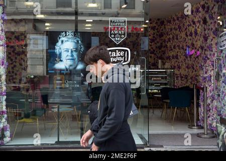 Un piéton passe devant un portrait de la reine Elizabeth II exposé dans une vitrine du centre de Londres. Banque D'Images