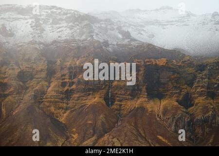 Falaise rugueuse avec cascades situées près des montagnes enneigées par temps froid d'hiver dans les hauts plateaux de l'Islande Banque D'Images