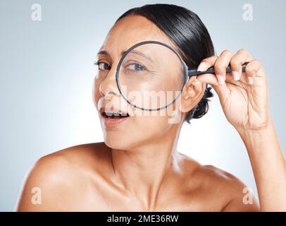 Loupe, soin de la peau et femme mûre dans un studio avec une routine de santé, de bien-être et de visage naturel. Beauté, beauté et portrait d'une femme Banque D'Images